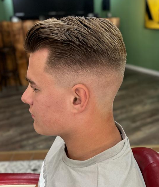 A mid-length pompadour haircut with midfade of a young man from the side