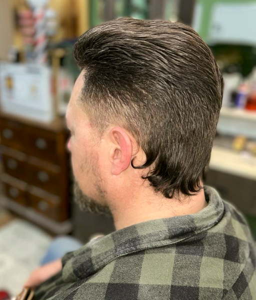 A mullet haircut of a man from the back