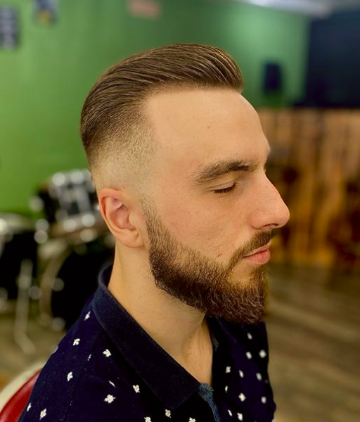 A classic high fade haircut with a clean lined up beard of a man from the side