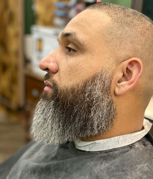 A clean mid-length length beard of aman from the side