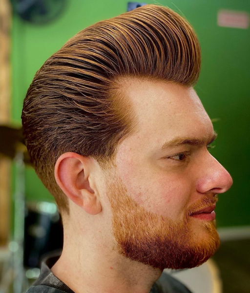 A red-hair pompadour haircut of a man from the side