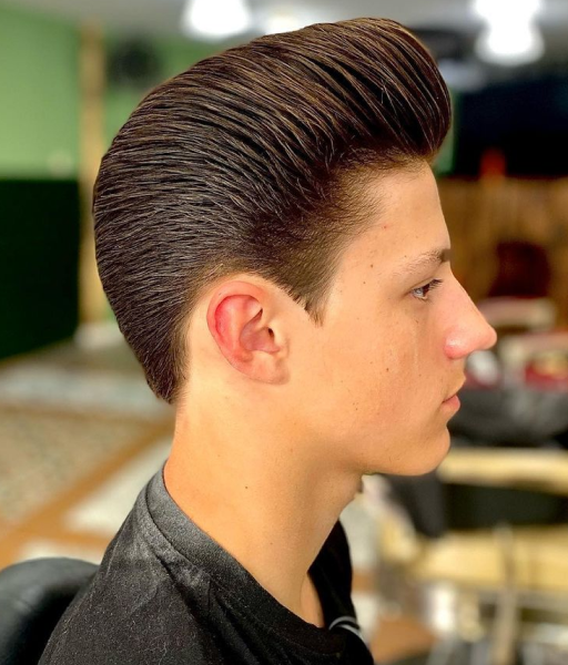 A red-hair pompadour haircut of a man from the side